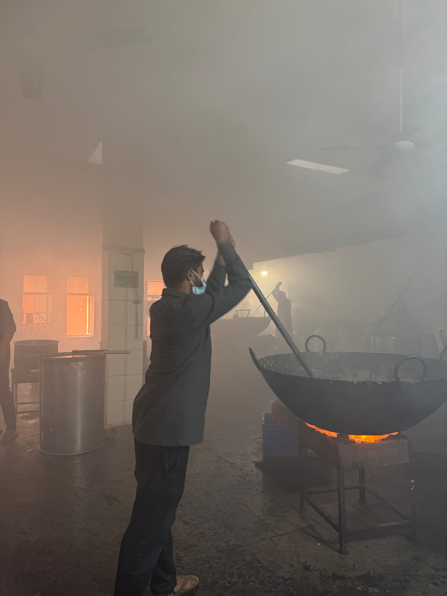 Herbal decoction simmering in a large vessel at an Ayurvedic pharmacy
